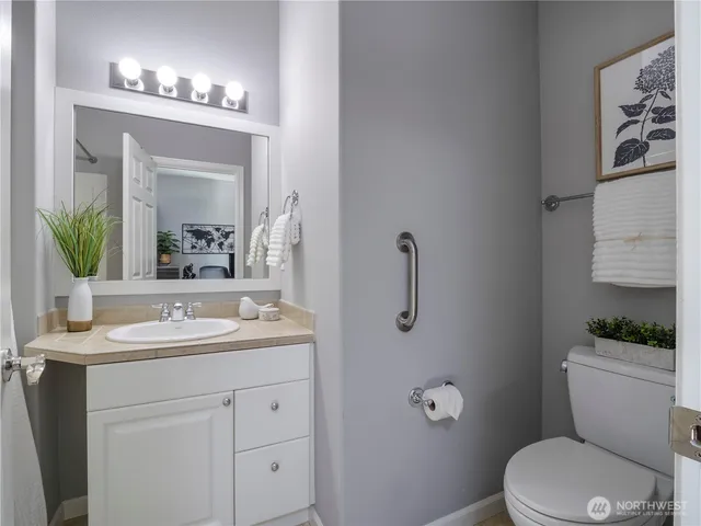 a bathroom with a toilet a sink and mirror