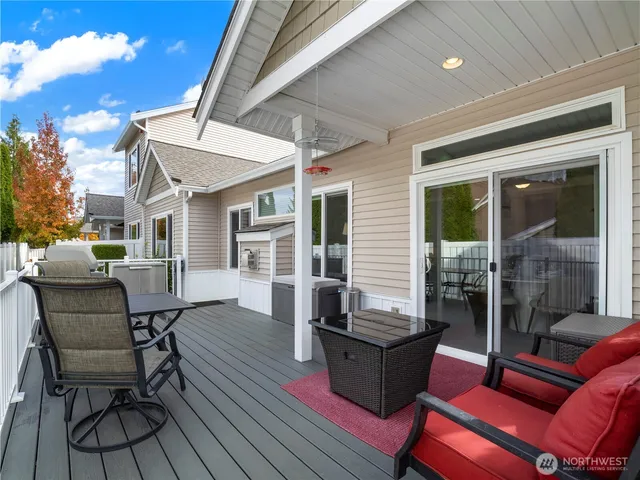 a view of a patio with table and chairs with wooden floor and fence