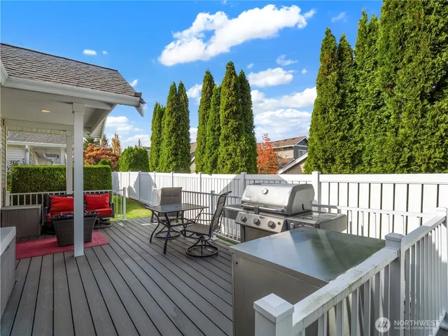 a view of a patio with table and chairs with wooden floor and fence