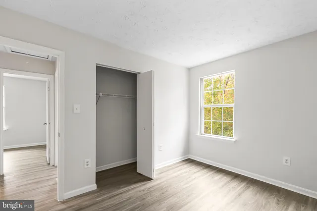 an empty room with wooden floor and a window