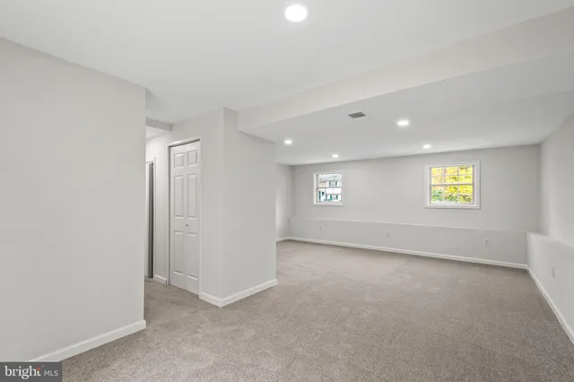 an empty room with a window and a ceiling fan
