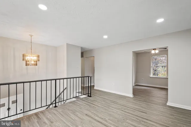 a view of a hallway with wooden floor and windows
