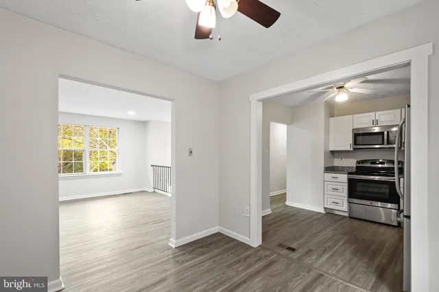wooden floor in an empty room with a kitchen