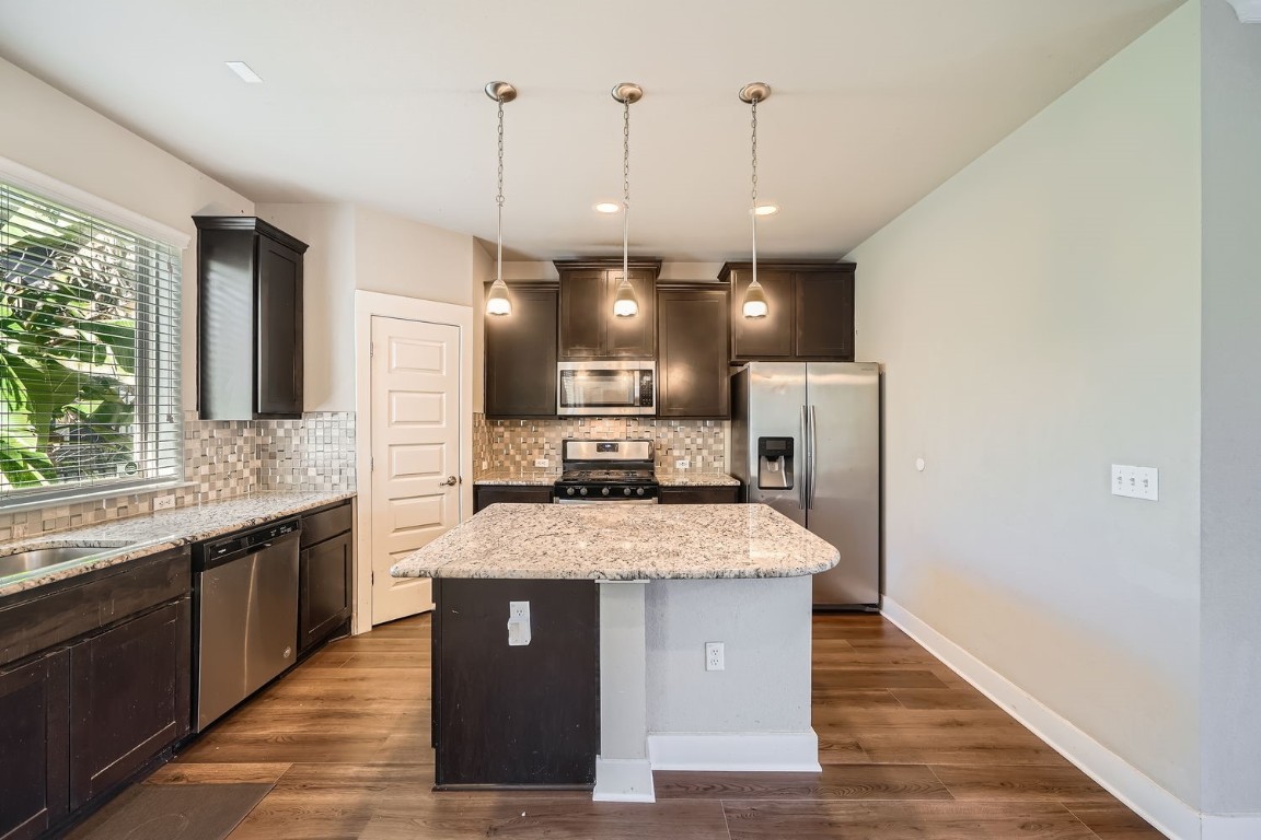 14709 Stillman Bend, Unit 52 Austin, TX 78717 - Photo 8 of 28 a large kitchen with a center island wooden floor and a large window
