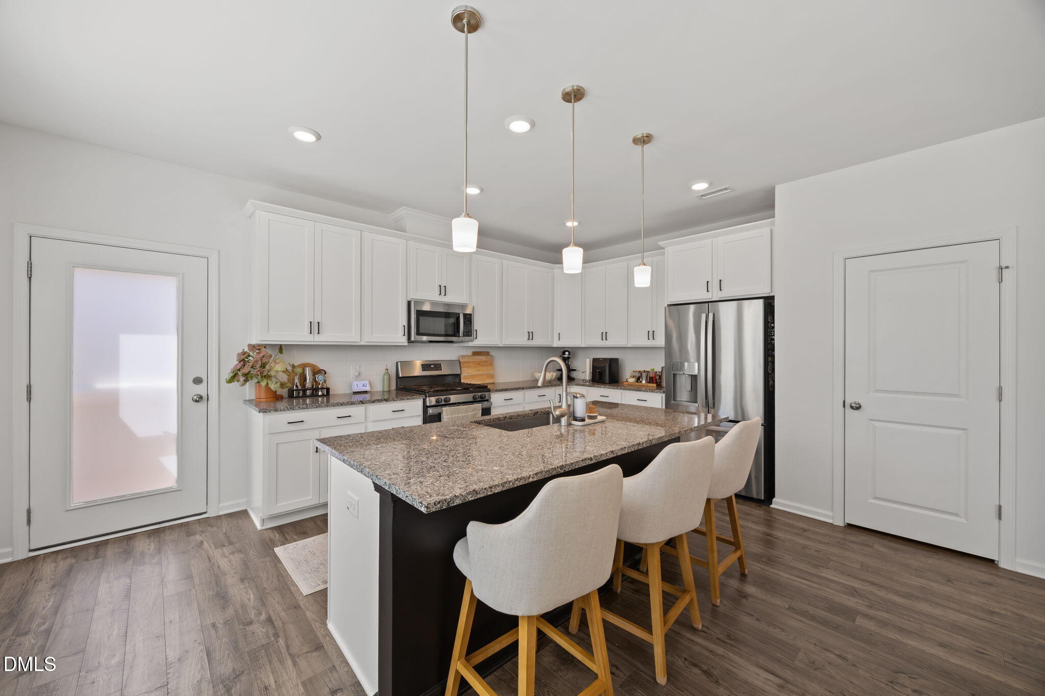 3013 Worthy Way Durham, NC 27703 - Photo 14 of 38 a kitchen with stainless steel appliances granite countertop a dining table chairs refrigerator and microwave