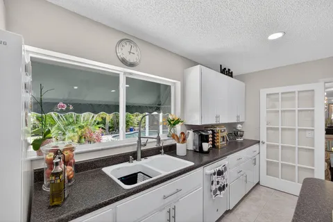 a spacious bathroom with a granite countertop sink a toilet and mirror