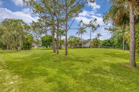 an aerial view of residential houses with outdoor space and trees