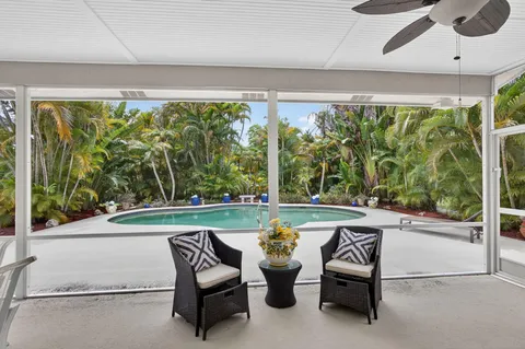 a living room with furniture flat screen tv and large window