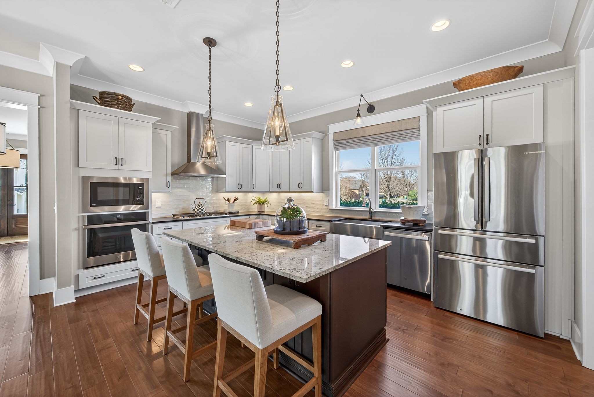 998 Spruce Ridge Lane Spring Hill, TN 37174 - Photo 31 of 82 a kitchen with stainless steel appliances granite countertop a refrigerator a stove a sink a dining table and chairs with wooden floor