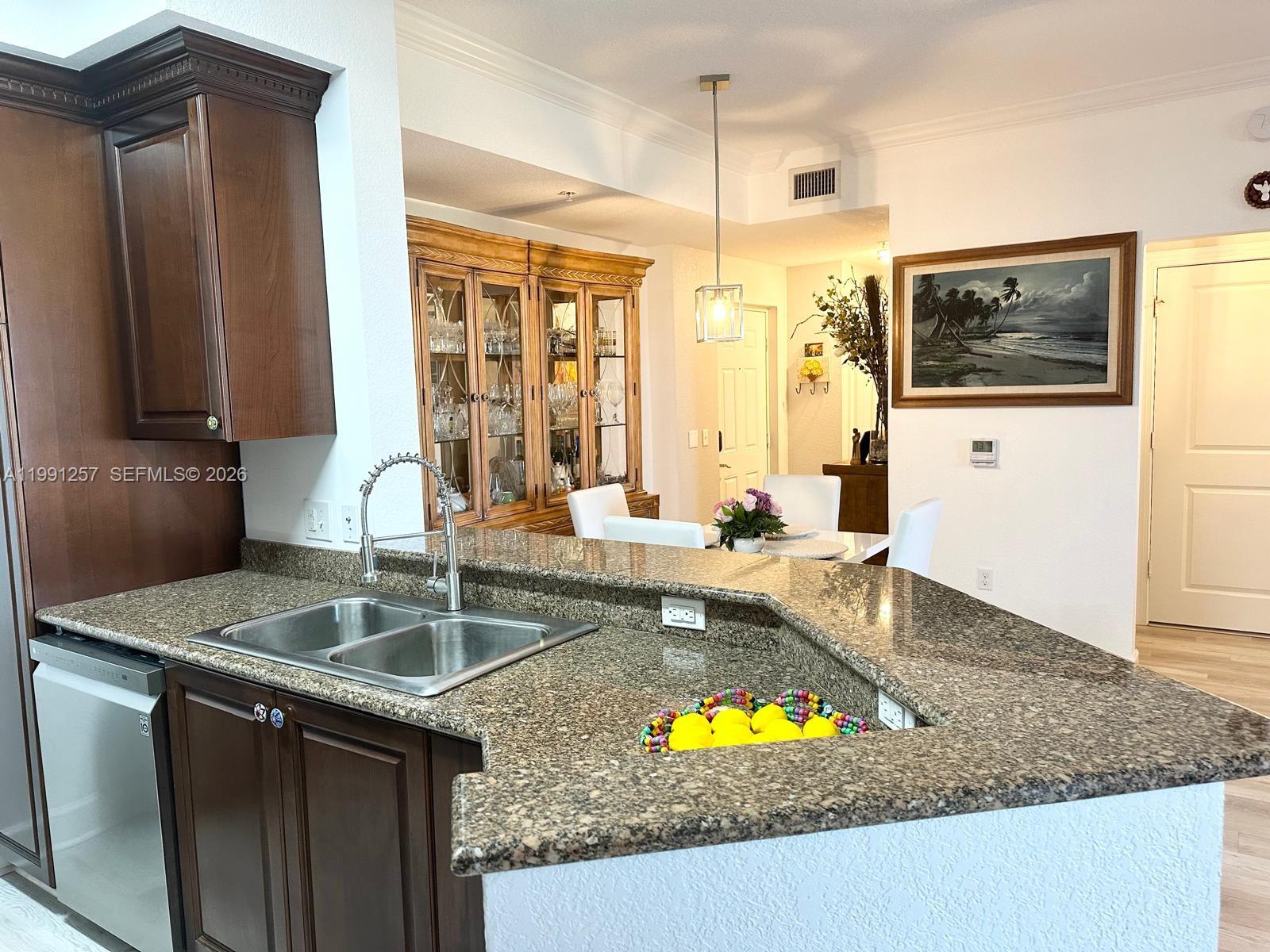 1660 Renaissance Commons Boulevard, Unit 2606 Boynton Beach, FL 33426 - Photo 6 of 26 a kitchen with kitchen island granite countertop a sink a stove and a granite counter top