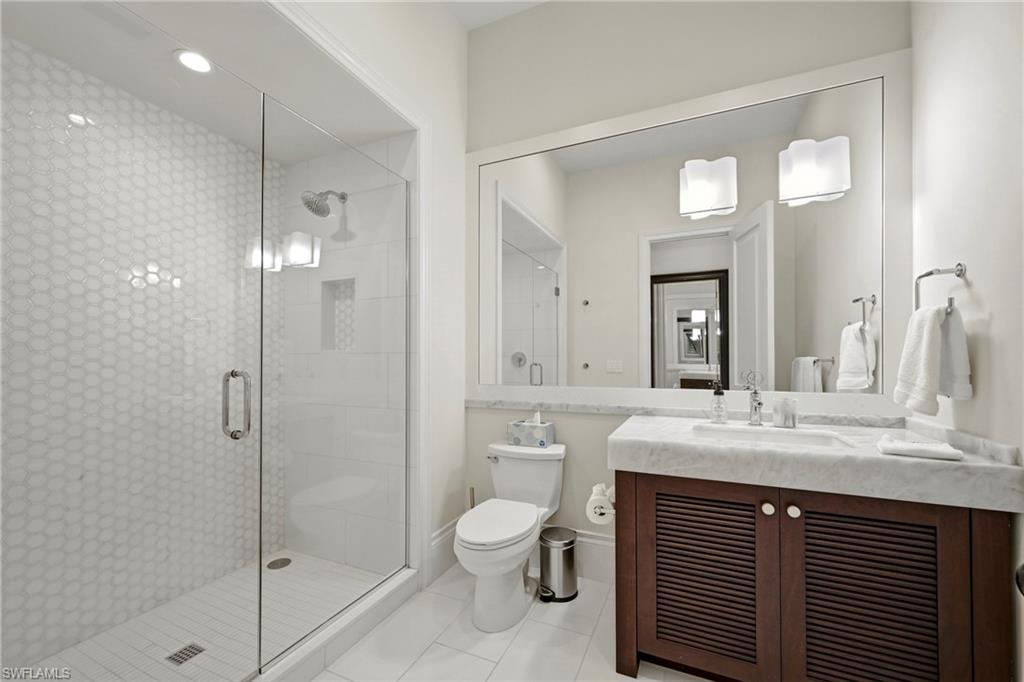 215 3rd Avenue North Naples, FL 34102 - Photo 33 of 47 Bathroom with vanity, a stall shower, and light tile patterned flooring