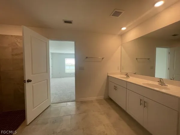 a spacious bathroom with a double vanity sink and a mirror