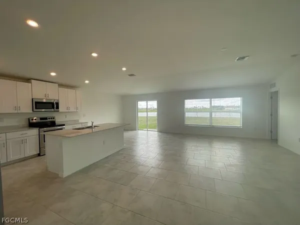 a large kitchen with stainless steel appliances a large counter top