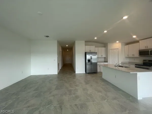 a kitchen with stainless steel appliances granite countertop a refrigerator and a stove top oven