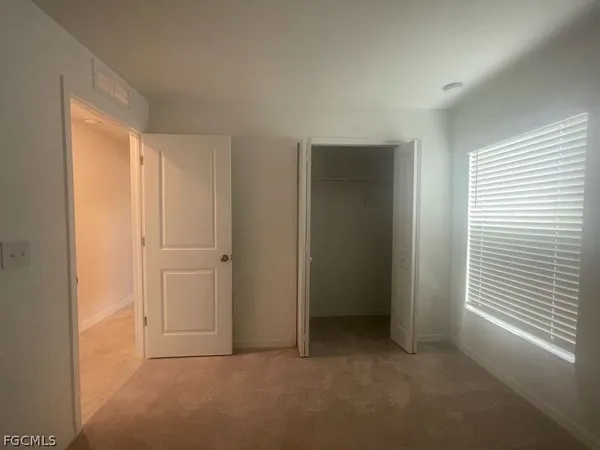 an empty room with windows and closet