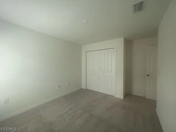 a view of an empty room and closet area
