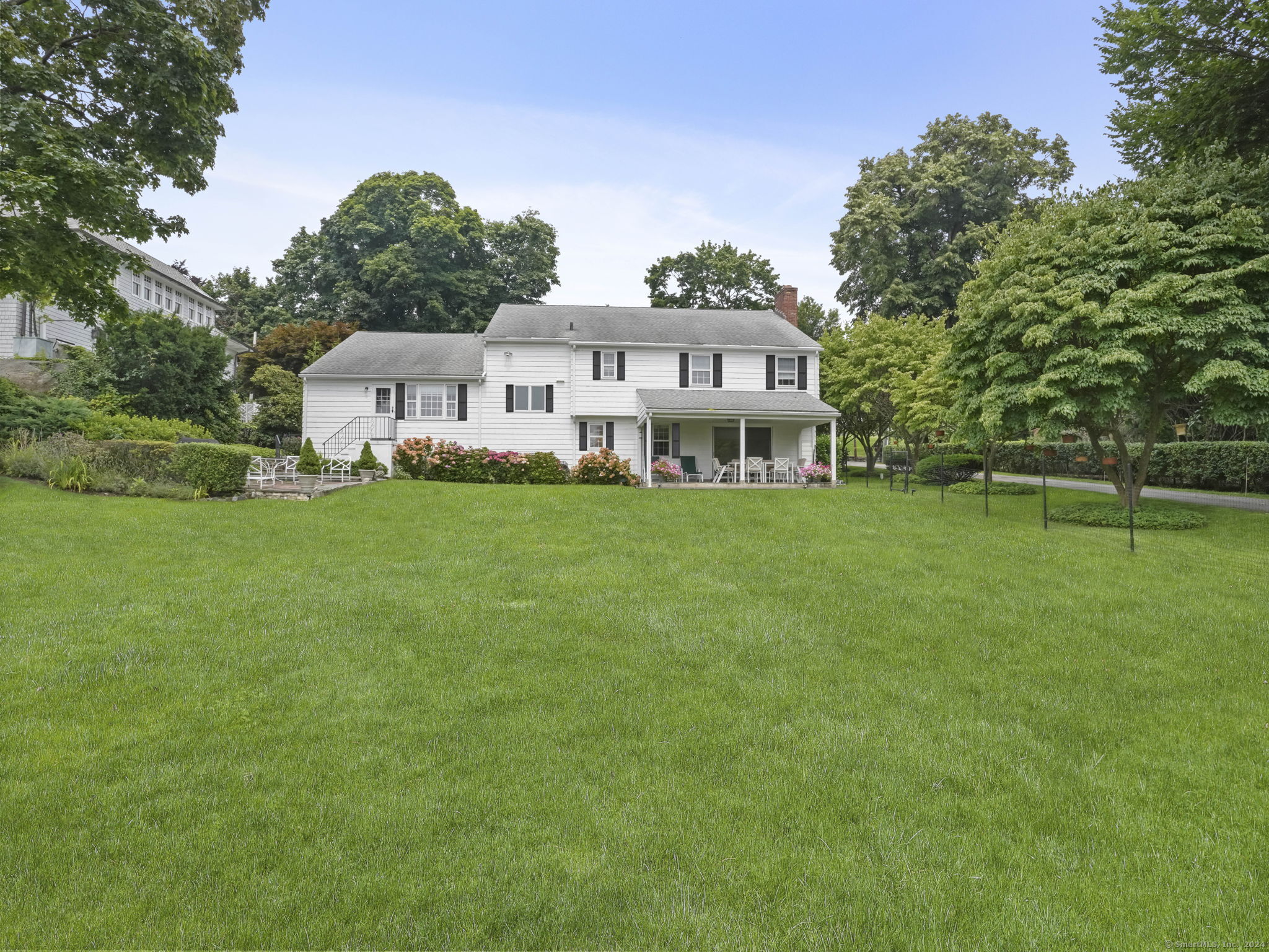a view of a house with a big yard and large trees