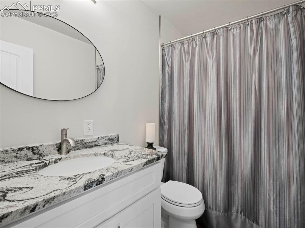 2622 Spring Grove Terrace Colorado Springs, CO 80906 - Photo 18 of 37 a bathroom with a granite countertop sink and a mirror