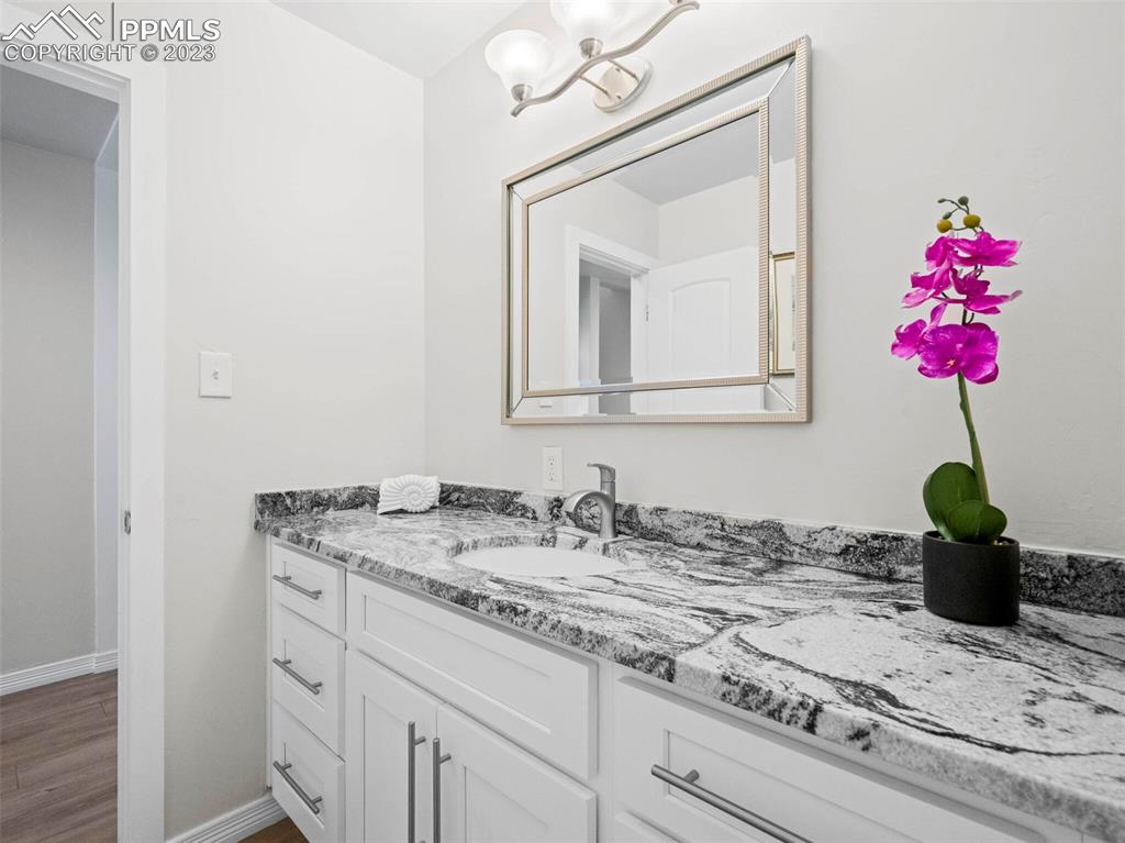 2622 Spring Grove Terrace Colorado Springs, CO 80906 - Photo 24 of 37 a bathroom with a granite countertop sink a vanity and a potted plant