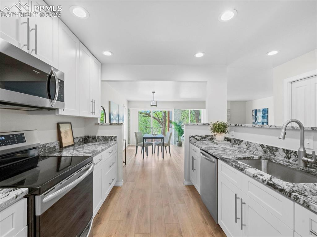 2622 Spring Grove Terrace Colorado Springs, CO 80906 - Photo 28 of 37 a kitchen with stainless steel appliances granite countertop sink stove microwave and cabinets