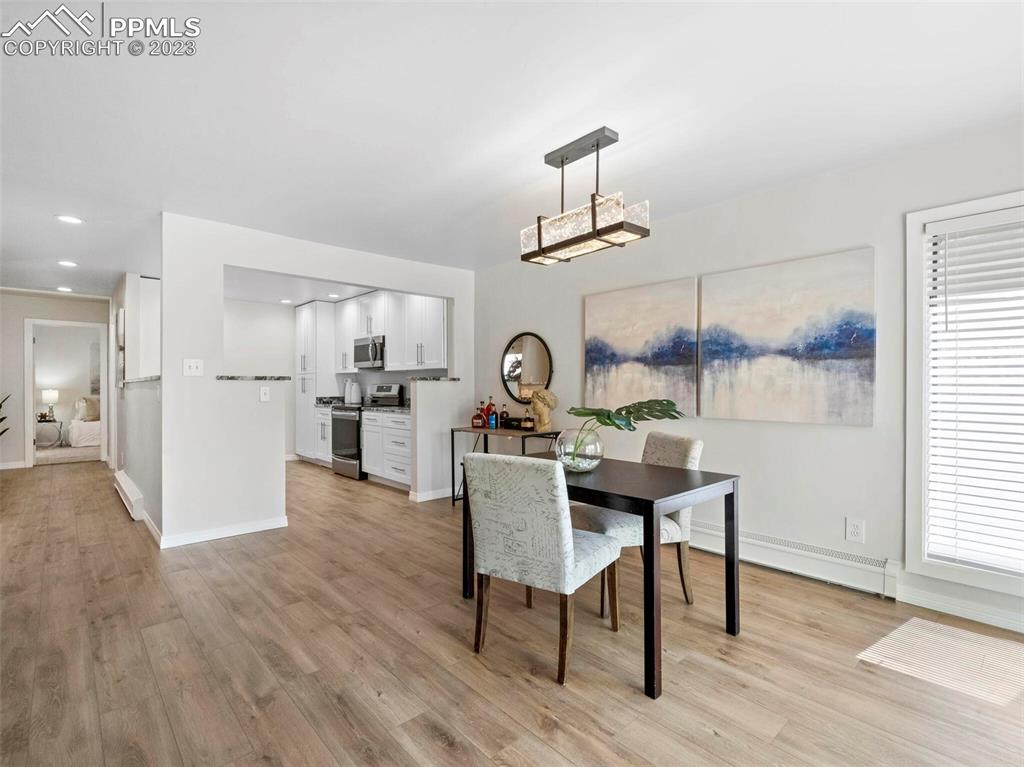 2622 Spring Grove Terrace Colorado Springs, CO 80906 - Photo 30 of 37 a view of a dining room and livingroom with furniture wooden floor a chandelier