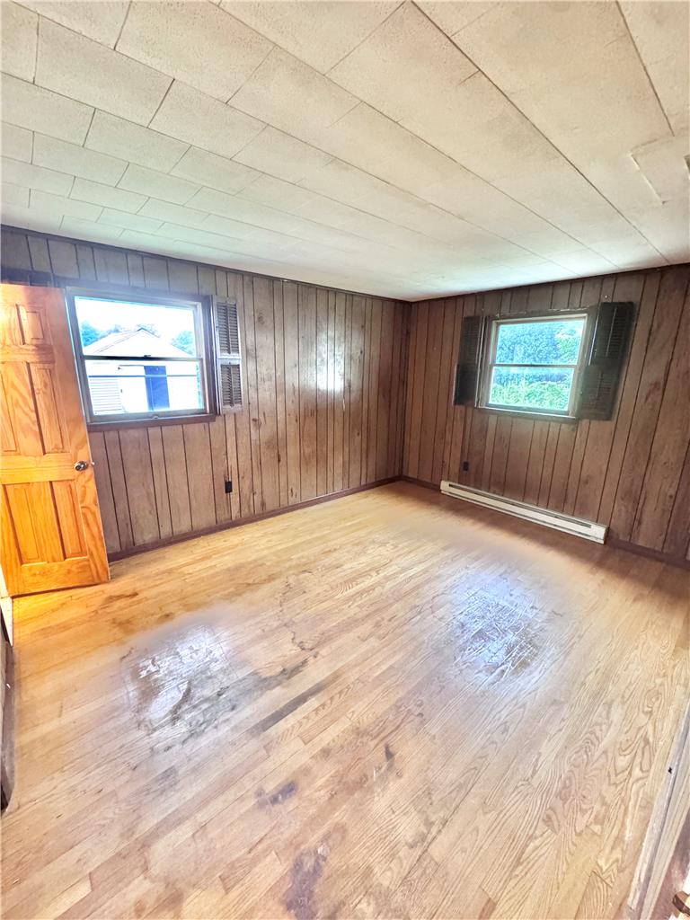 8325 Schantz Road Breinigsville, PA 18031 - Photo 14 of 21 Hardwood floors and paneled walls create a rustic foundation for this bedroom space.