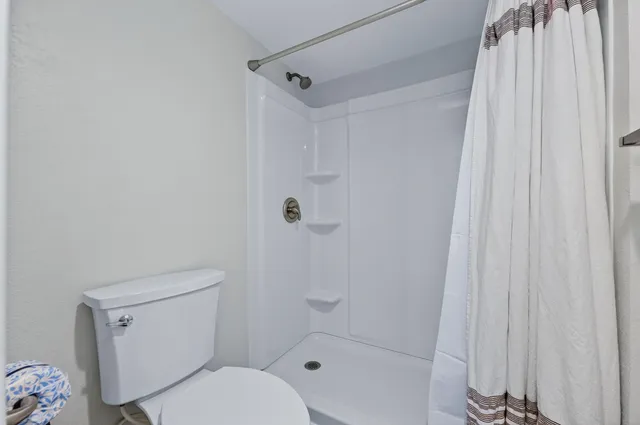 a white toilet sitting next to a bath tub