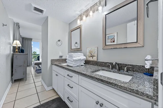 a bathroom with a granite countertop sink mirror and a toilet