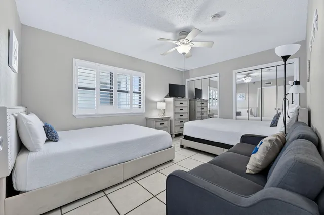 a bedroom with bed couch and window