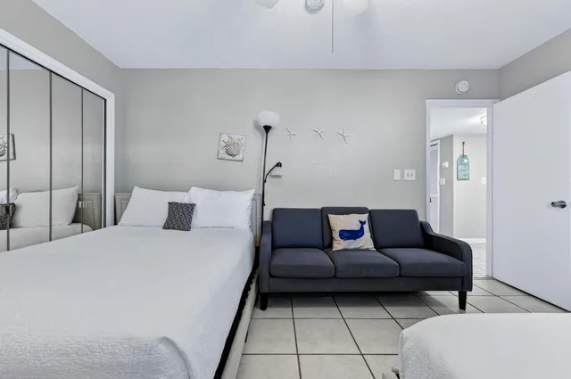 a living room with a couch and a walk in closet with wooden floor