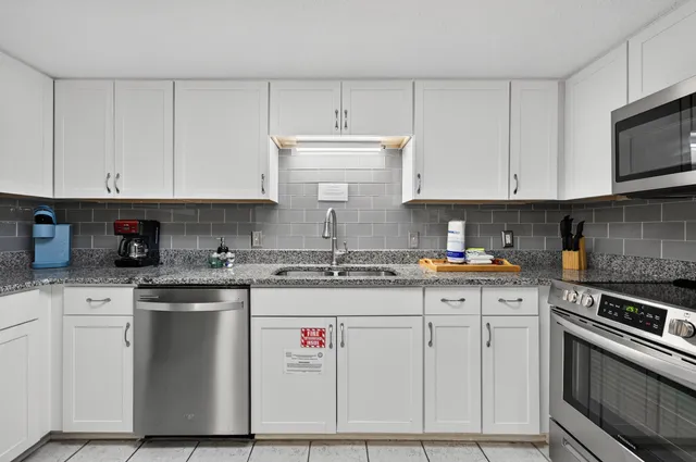 a kitchen with stainless steel appliances granite countertop a sink and cabinets