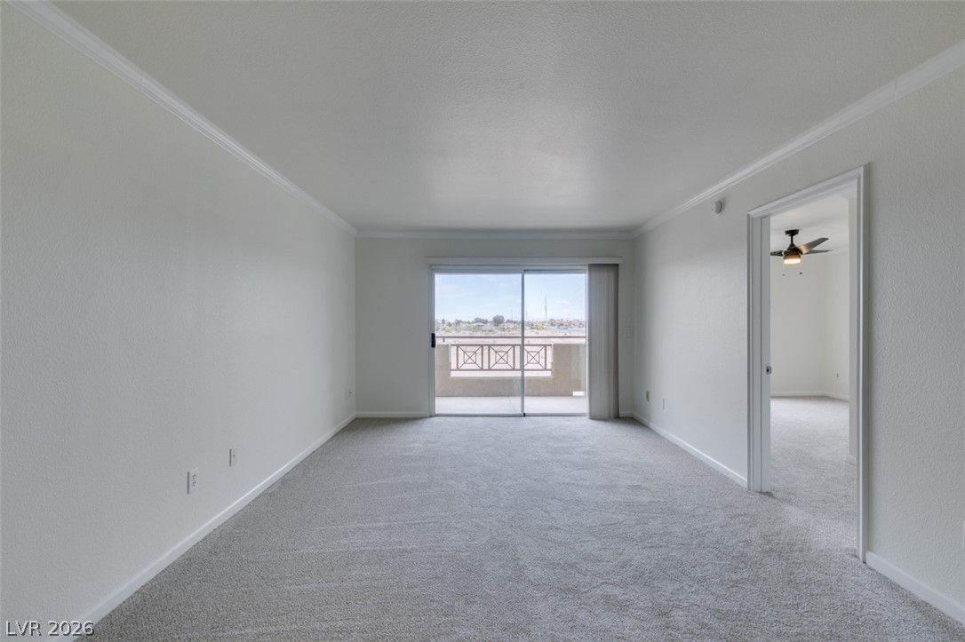 8070 West Russell Road, Unit 2026 Las Vegas, NV 89113 - Photo 14 of 41 A spacious, naturally illuminated room features plush carpeting and sliding doors opening to an outdoor balcony.