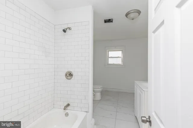 a white toilet sitting next to a window