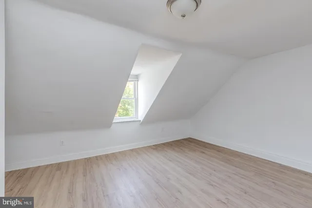 a view of an empty room with wooden floor and stairs