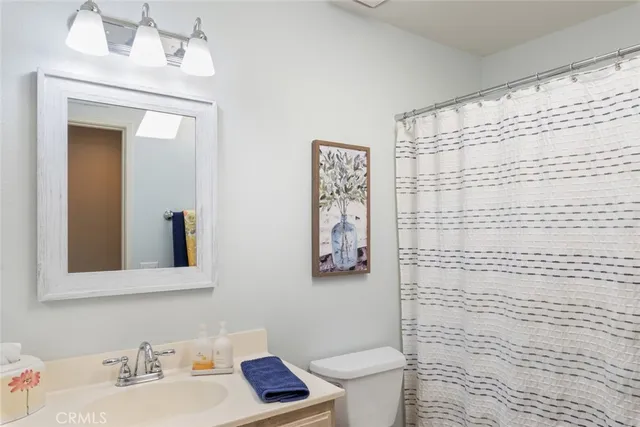 a bathroom with a sink a toilet and shower curtain