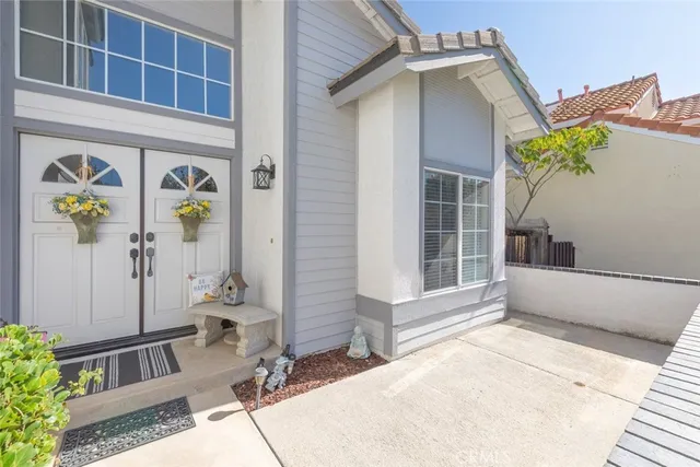 a front view of a house with a garden and trees