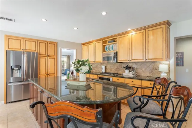 a kitchen with stainless steel appliances granite countertop a stove a sink and a refrigerator