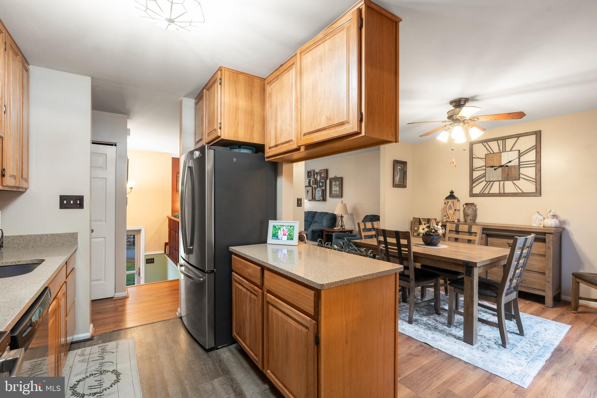 14 Stable Gate Court Perry Hall, MD 21128 - Photo 7 of 46 a kitchen with sink a refrigerator a stove and chairs with wooden floor