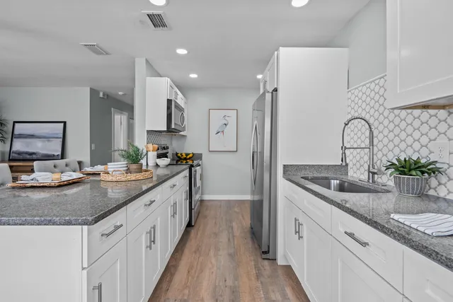 a kitchen with sink stove and refrigerator