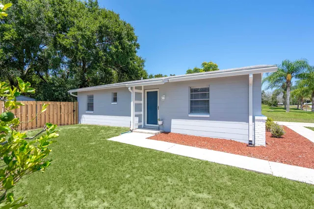 a backyard of a house with table and chairs