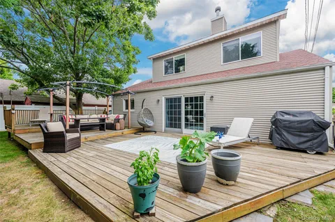 a view of house with patio outdoor seating and covered with trees