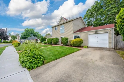 a view of a house with a big yard and potted plants