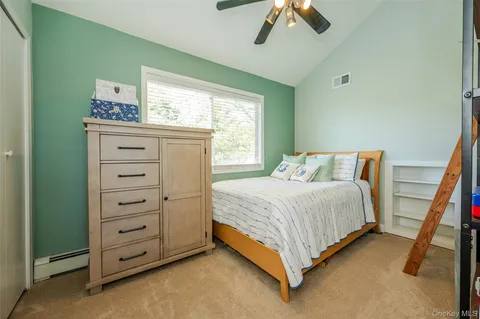 a bedroom with a bed and a flat tv screen on the dresser