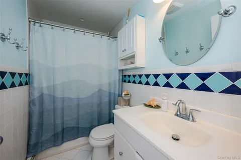 a bathroom with a sink and mirror with toilet