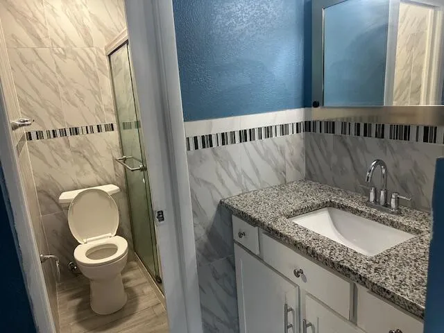 a bathroom with a granite countertop toilet sink and mirror