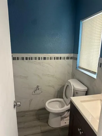a bathroom with a toilet a sink and a window