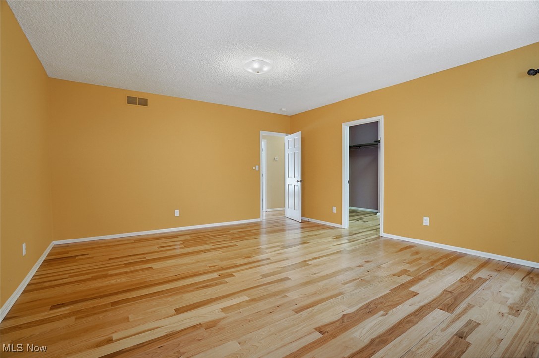 1094 San Raphael Drive Akron, OH 44333 - Photo 29 of 50 Unfurnished bedroom with a spacious closet, a textured ceiling, and light wood finished floors
