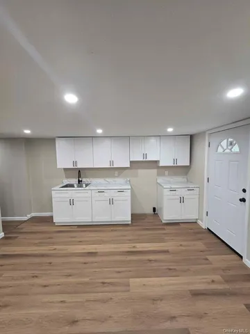 a large white kitchen with kitchen island in the center