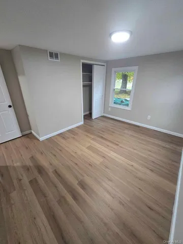 an empty room with windows and closet