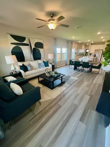 a kitchen with stainless steel appliances kitchen island granite countertop a stove top oven a sink a dining table and chairs with wooden floor